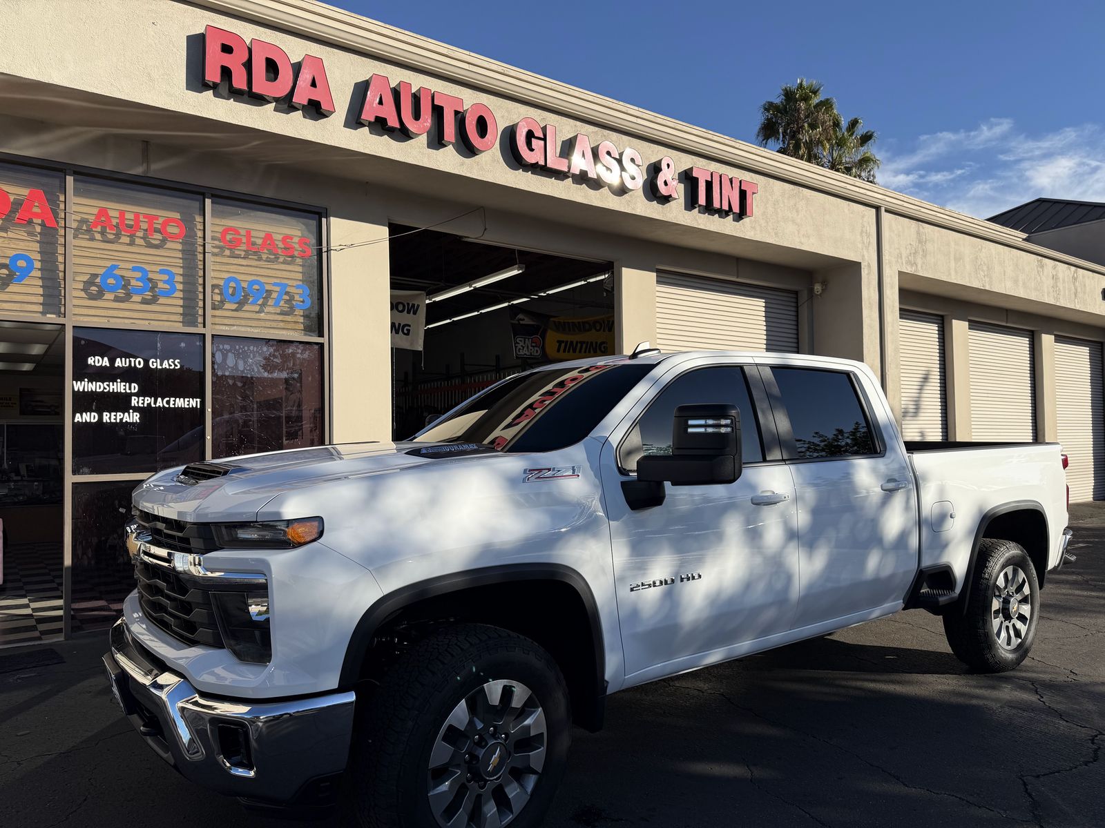 White Silverado at the RDA Auto Glass & Tint storefront